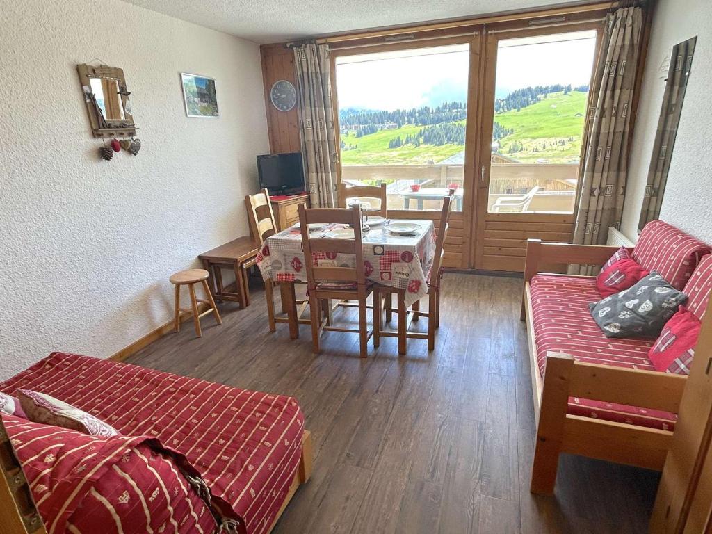 un salon avec un canapé et une table ainsi qu'une salle à manger dans l'établissement Studio cabine pour 4 personnes avec balcon exposé sud, au cœur des Saisies - FR-1-594-108, à Hauteluce
