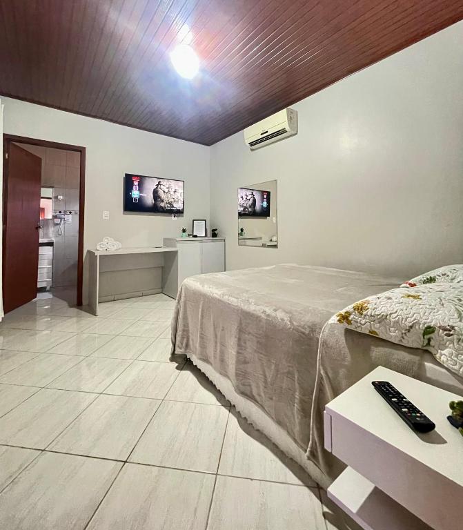 a bedroom with a bed and two monitors on the wall at Kitnet Espaço Aconchego in Alfredo Wagner