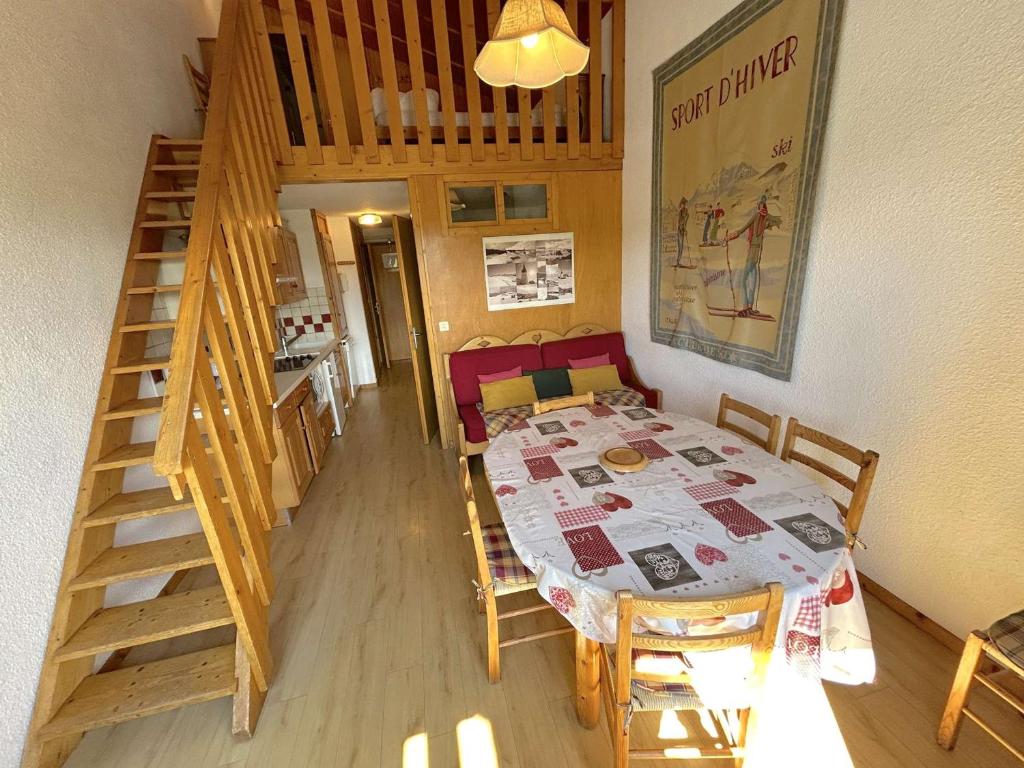 une salle à manger avec une table et des chaises et un escalier dans l'établissement Appartement 2 pièces cabine 8 personnes, balcon sud, central aux Saisies - FR-1-594-50, à Hauteluce