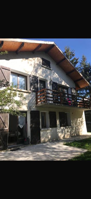 Cette grande maison blanche dispose d'un balcon. dans l'établissement Ancelle le plantier, à Ancelle