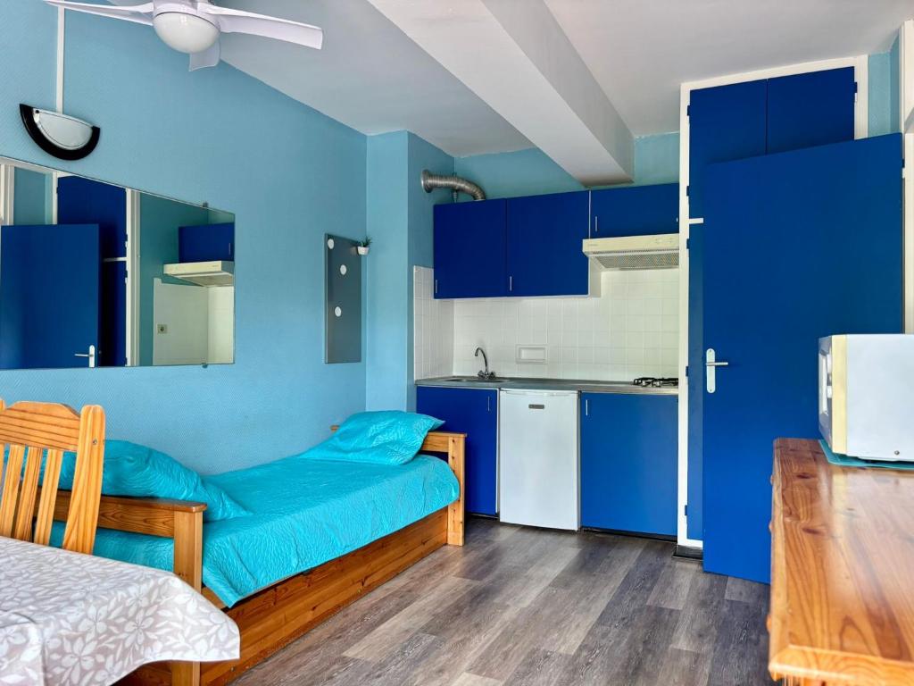 Cette chambre bleue comprend un lit et une cuisine. dans l'établissement Belle Appartement T2 Plage Centrale Argeles sur mer 2, à Argelès-sur-Mer