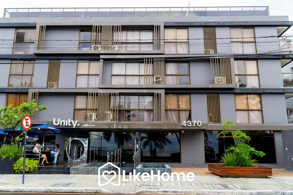 a building with people sitting outside of it at Unity Cabo Branco - LikeHome Hospedagens in João Pessoa