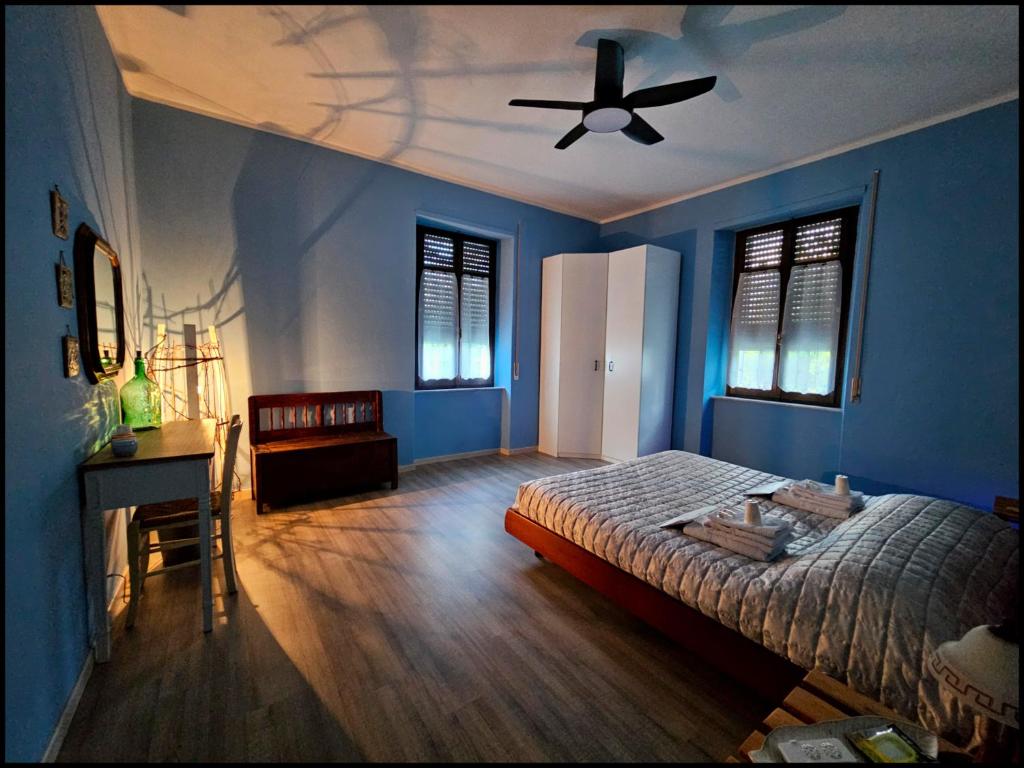 a blue bedroom with a bed and a ceiling fan at Narnia e la Rocca di Albornoz in Narni