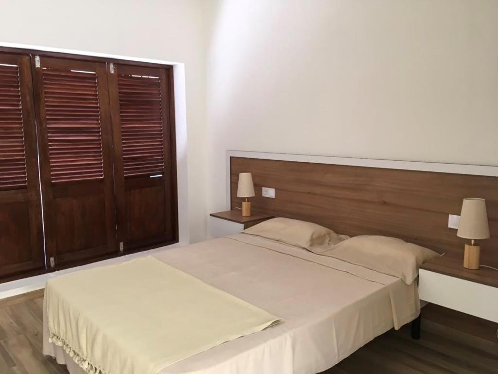 a bedroom with a large bed with a wooden headboard at Alana's loft in Praia