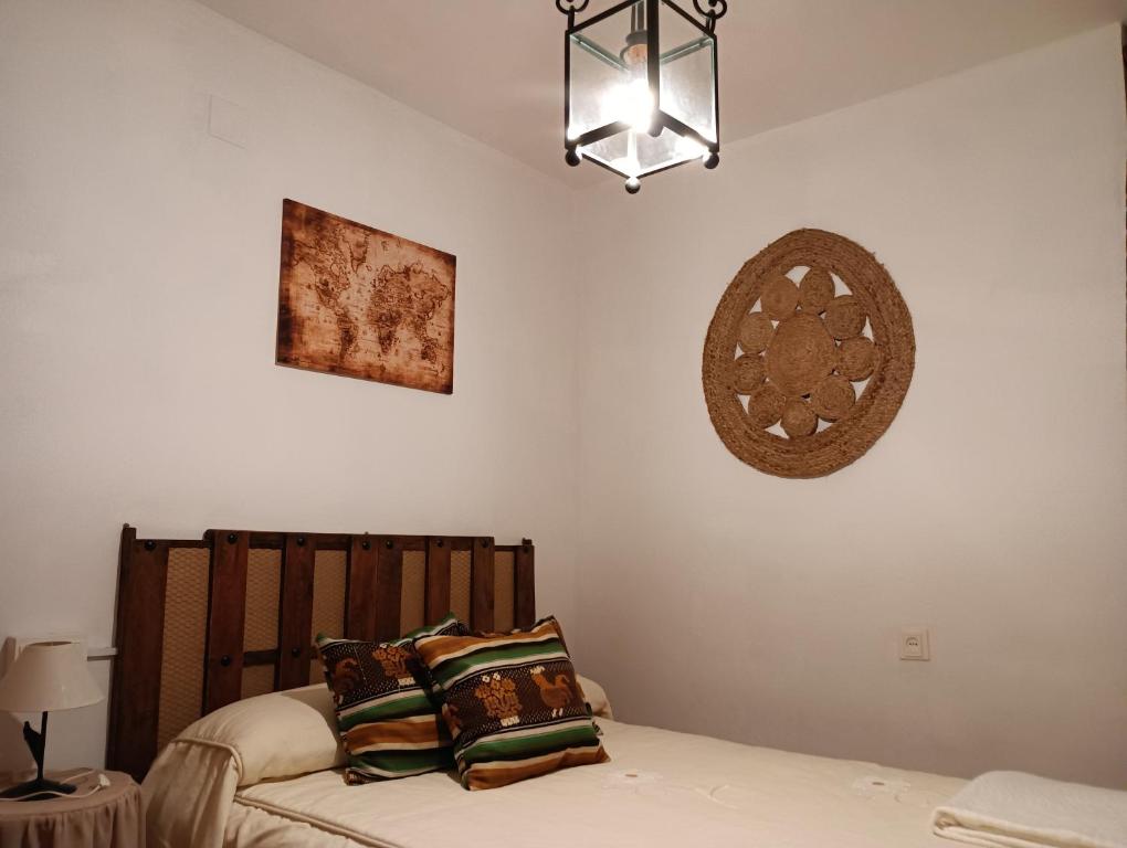a bedroom with a bed and a chandelier at La Atalaya de Los Romanes in Viñuela