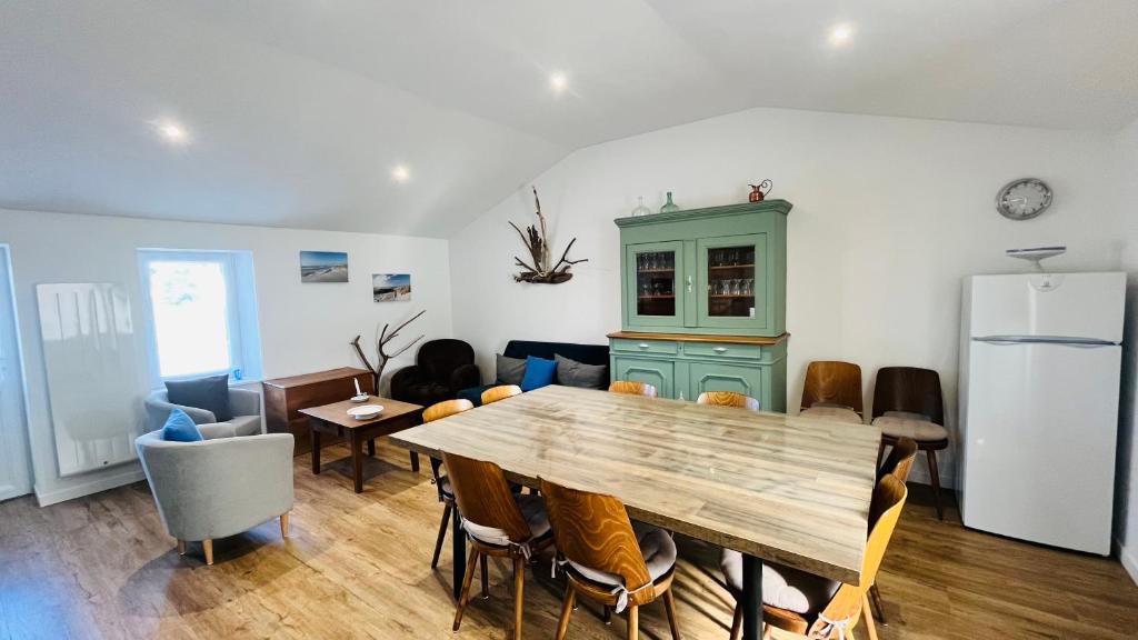une salle à manger avec une table et un réfrigérateur dans l'établissement Maison du petit moulin, à Soullans