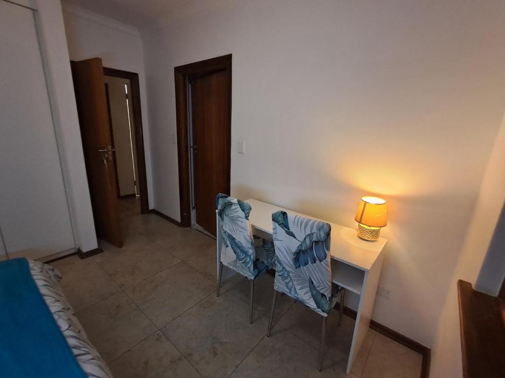 Una habitación con una mesa con dos sillas y una lámpara. en Villa Theresa, en Johannesburgo