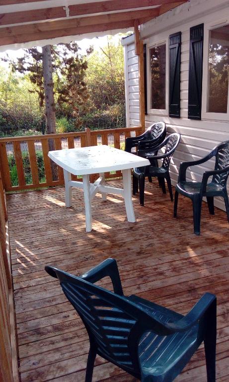 d'une terrasse avec une table blanche et des chaises. dans l'établissement Mobile home, à Agde
