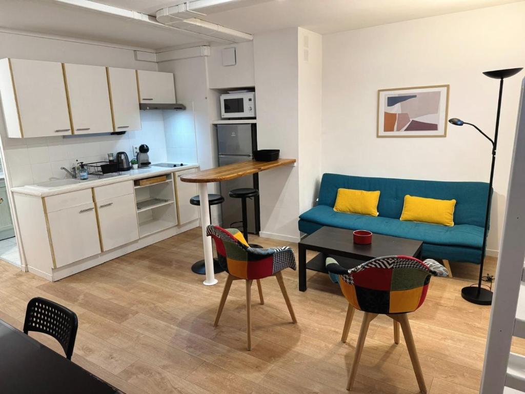 un salon avec un canapé bleu et une cuisine dans l'établissement Appartement tout équipé à coté de la Timone Marseille, à Marseille