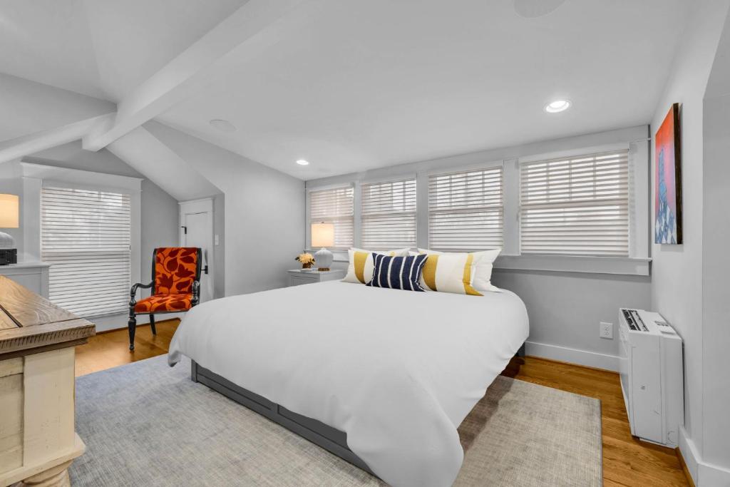 a bedroom with a large white bed and a chair at Historic West End Guest Studio Suite by SkyRun Nashville in Nashville