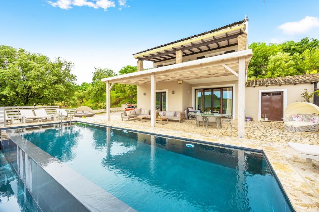 a swimming pool in front of a house at Villa Antinoti in Agía Aikateríni