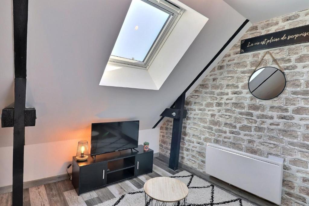 a loft conversion with a skylight and a brick wall at Les Apparts du Pont Vert - lit double - WiFi - tout inclus - 4 in Troyes