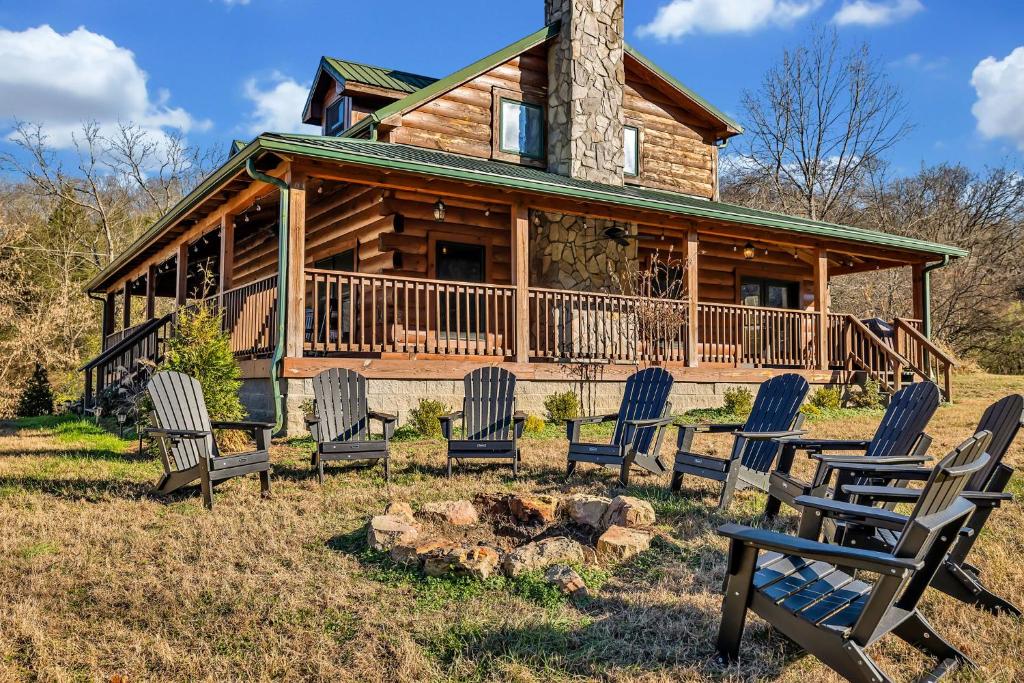 una baita di tronchi con sedie e braciere di Creeks Cabin Luxury Retreat 15 min to Downtown Nashville a Whites Creek