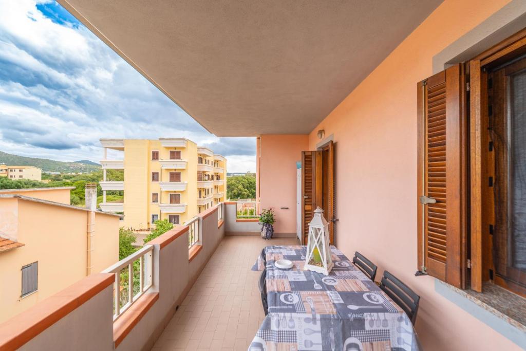 a balcony with two tables and a view of a building at casa illaria in Olbia