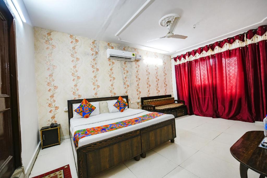 a bedroom with a bed and red curtains at FabExpress Diamond Sec 45 in Chandīgarh