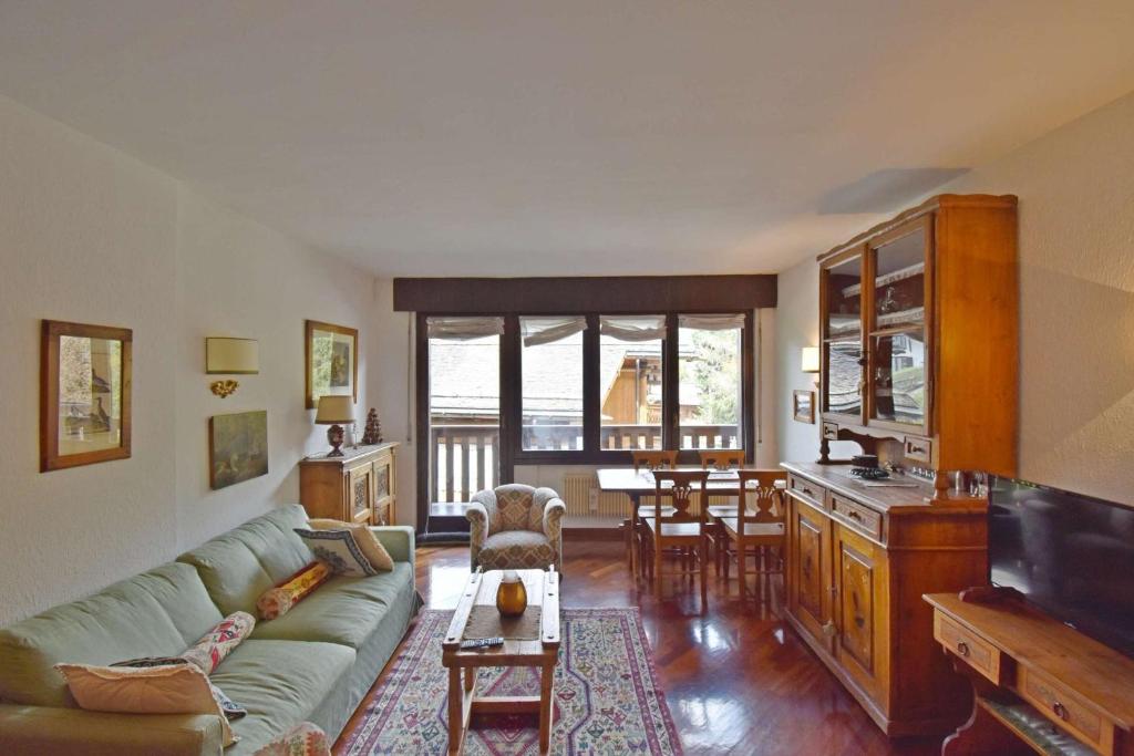 マドンナ・ディ・カンピリオにあるPresanella Alpine Apartment Mhdのソファとテーブルのあるリビングルーム