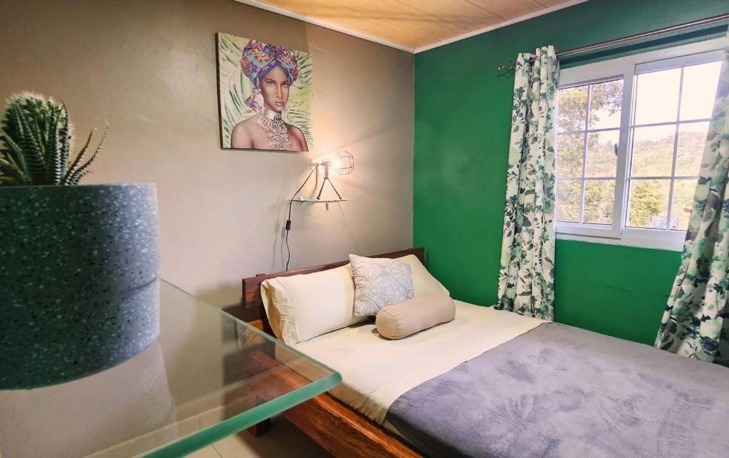 a green room with a small bed and a window at Rio Sereno Haus mit Garten - Grenze zu Costa Rica in Río Sereno
