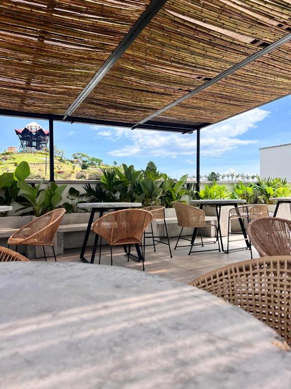 a patio with tables and chairs and a view at Monte Pueblo Hotel Boutique in Filandia