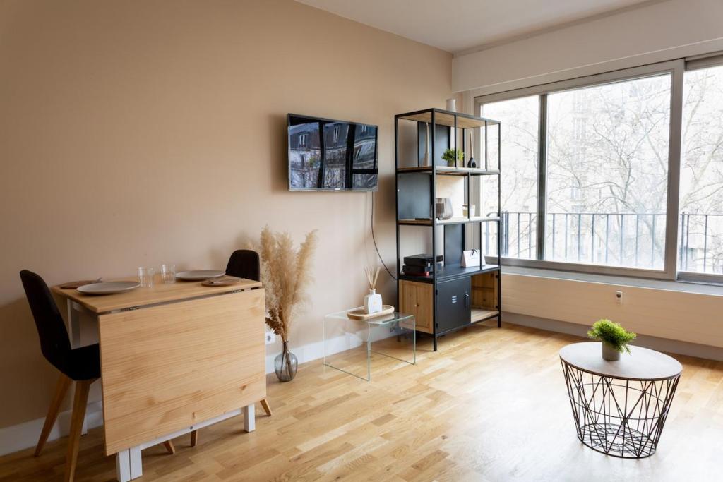 un bureau avec un bureau et une grande fenêtre dans l'établissement Charming Moulin Rouge Studio, à Paris