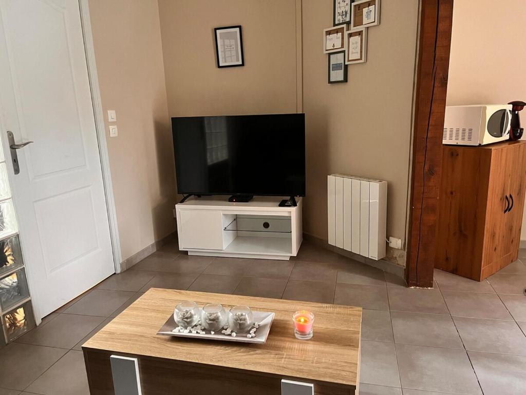 un salon avec une télévision et une table basse dans l'établissement Appartement à Dieppe, à Dieppe