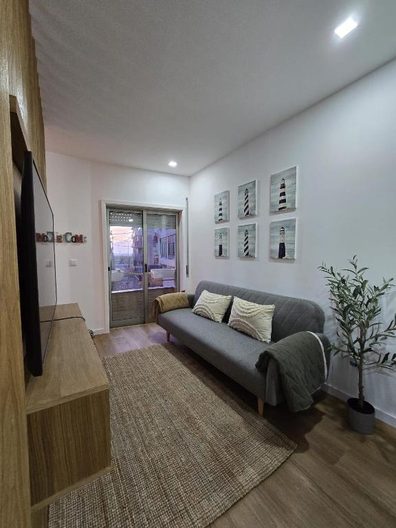 een woonkamer met een bank en een tv bij Cantinho Averomar in Póvoa de Varzim