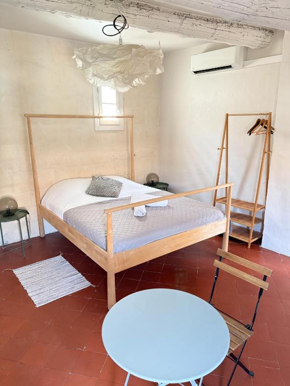 Un dormitorio con una cama, una mesa y una silla. en Les chambres Saint-Roch, en Arles