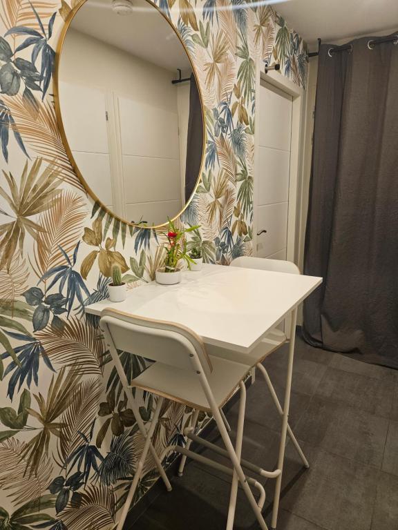 une salle de bain avec un miroir et une table et des chaises blanches dans l'établissement Chambre proche gare et hôpital, à Vannes