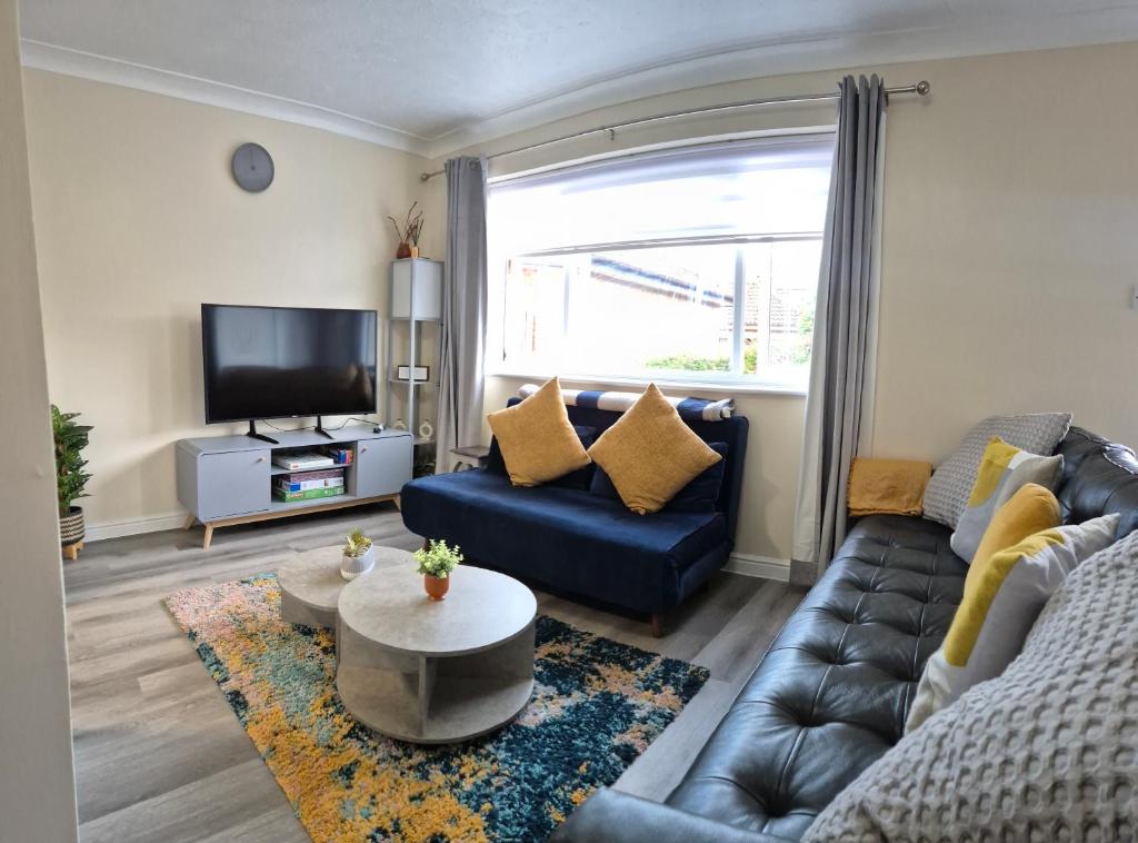 a living room with a couch and a tv at Cosy 2 Bedroom House Stevenage Old town Close to Train Station Free Parking Sleeps 4-6 in Stevenage