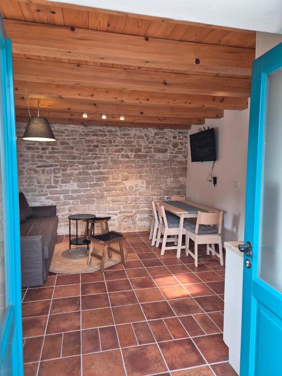 a living room with a brick wall and a table at Akvamarin Stone House Istria in Medulin