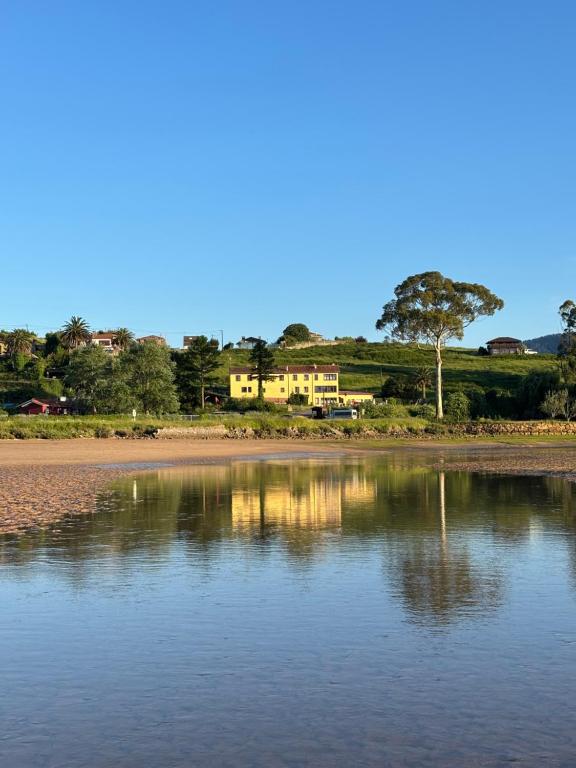 a house is reflected in the water on a beach at Casa de Aldea Misiego Rodiles in Selorio