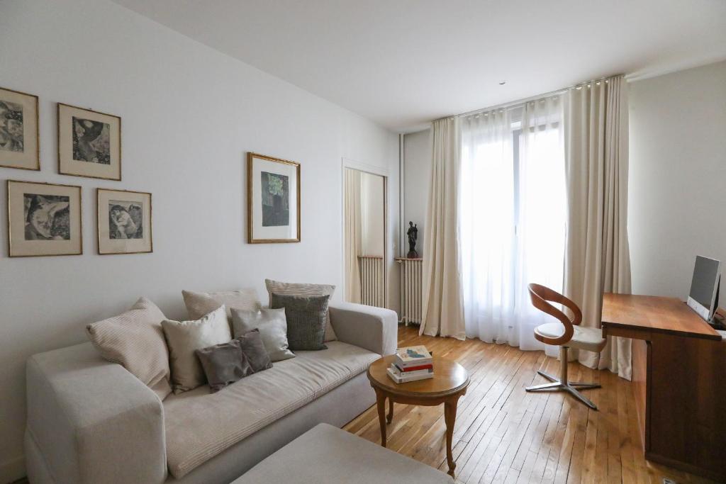 un salon blanc avec un canapé et une table dans l'établissement Bright apartment for 4 with balcony, à Paris