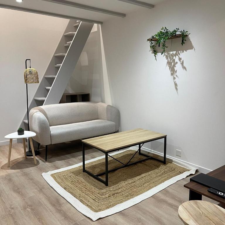 un salon avec un canapé et une table dans l'établissement Le Vox Appart', à Montélimar