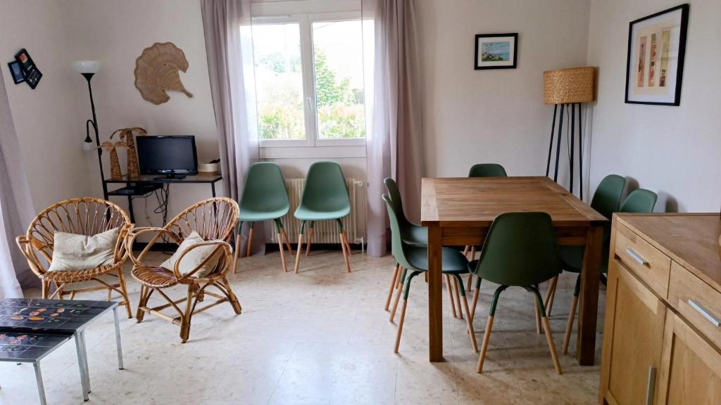 une salle à manger avec des chaises vertes et une table en bois dans l'établissement Maison pittoresque à Argelès-sur-Mer avec jardin clôturé, à Argelès-sur-Mer