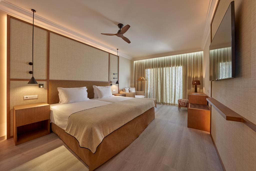 a bedroom with a large bed with a ceiling fan at PortoBay Blue Ocean in Albufeira