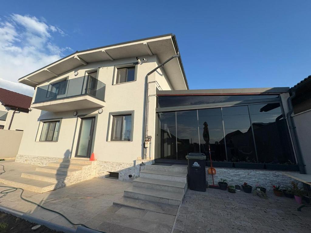 ein großes Haus mit Glastüren und einem Mülleimer in der Unterkunft Casa Agigea in Agigea