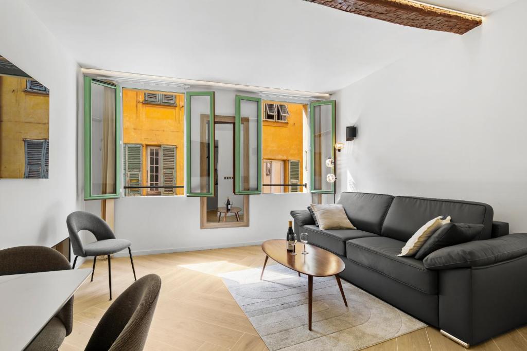 un salon avec un canapé noir et une table dans l'établissement Saint-Augustin - Nice Old Town, à Nice