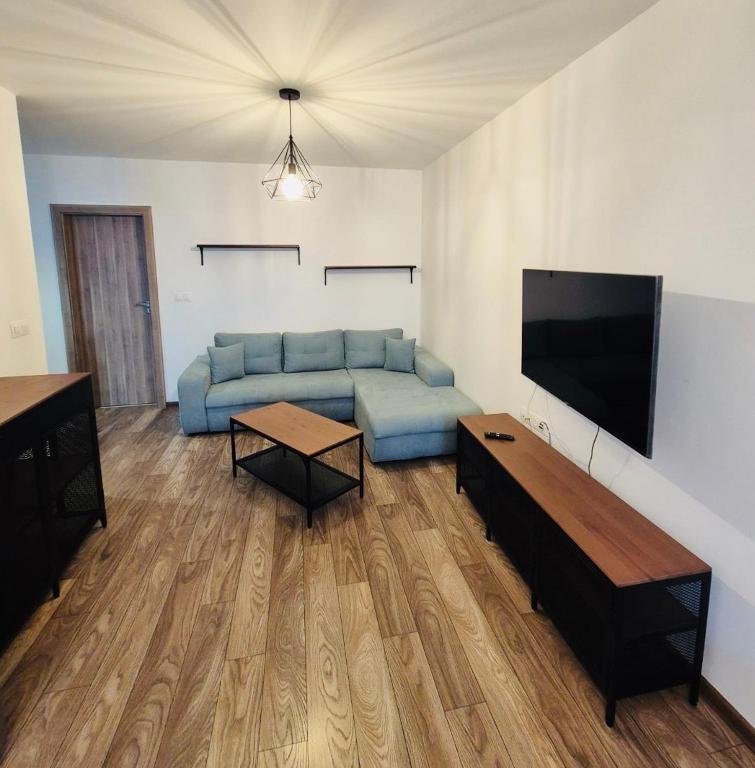 a living room with a blue couch and a flat screen tv at Milan Luxury Apartaments X in Târgu-Mureş