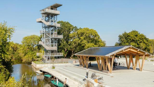 un bâtiment avec un pavillon à côté d'une rivière dans l'établissement Maisonnette entre terre et mer, à Saint-Malo-de-Guersac