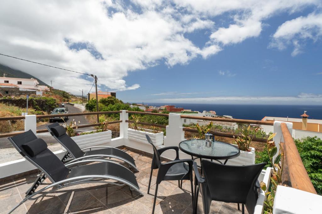 a balcony with a table and chairs and the ocean at Pozo del deseo in Frontera