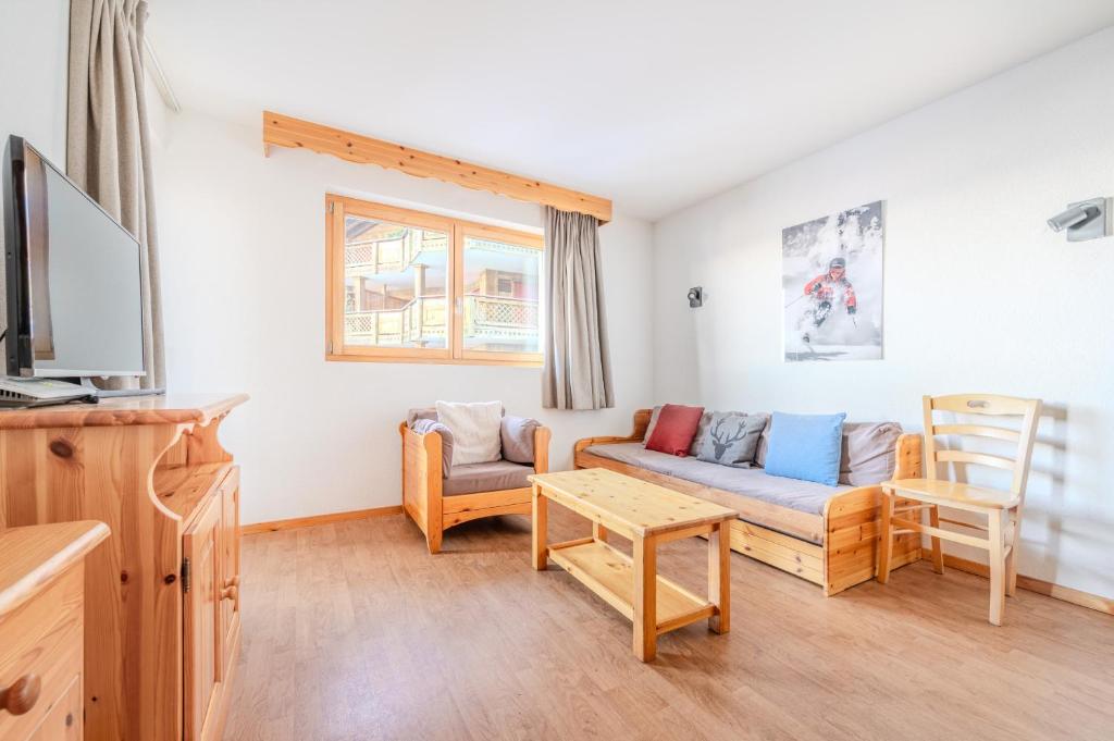 a living room with a couch and a tv at Pracondu 1 304 - OUTDOOR & FUN charming apartment in Nendaz