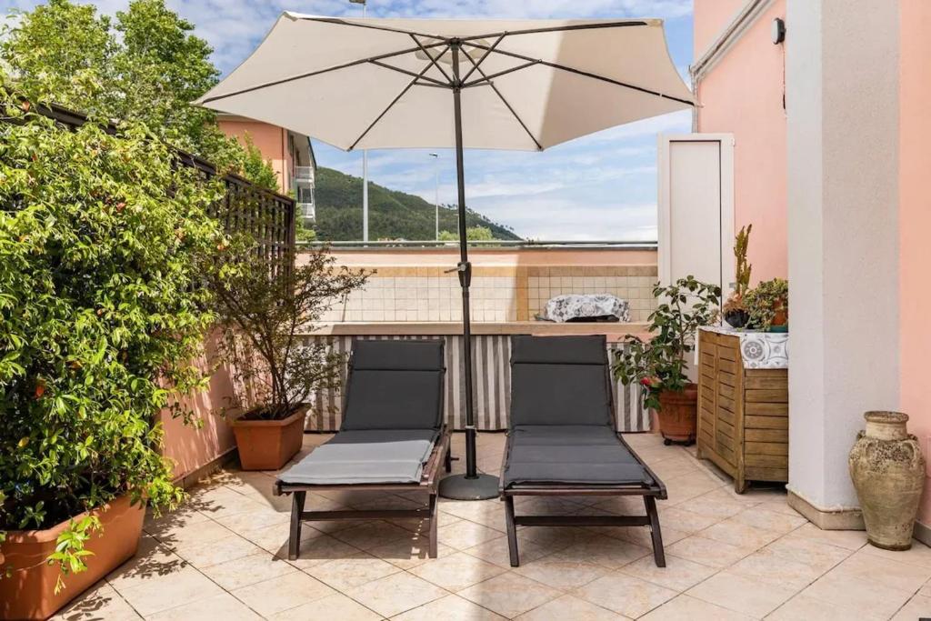 a patio with two chairs and an umbrella at Modern Apartment in La Spezia with Stunning Views - 75 m² in La Spezia