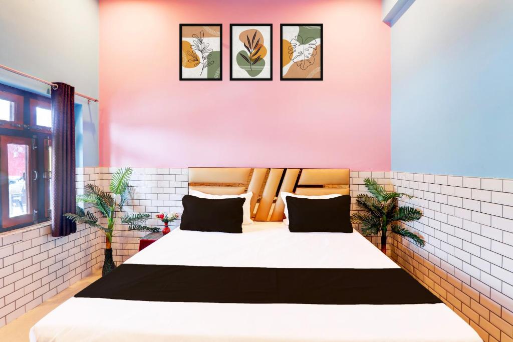 a bedroom with a large bed with four pictures on the wall at Hotel O Usha Marriage Lawn & Resort in Mahmūdābād