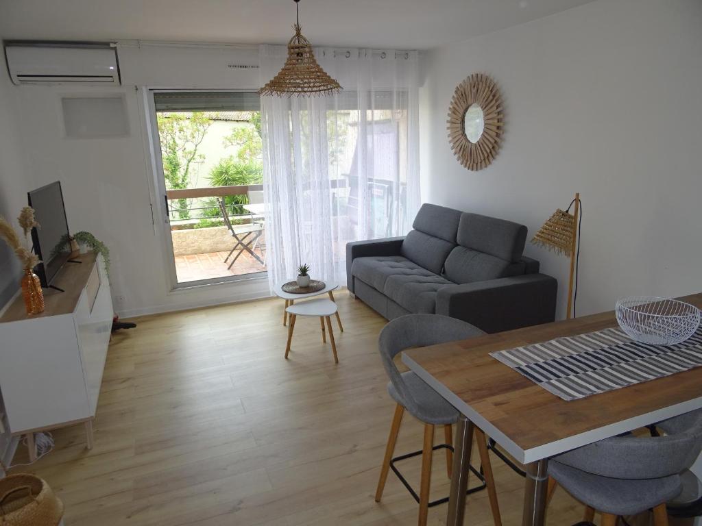 un salon avec un canapé et une table dans l'établissement Résidence Le Bali, à La Ciotat