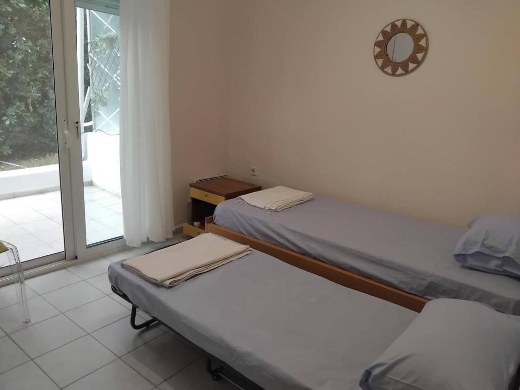 two twin beds in a room with a window at Spacious apartment Nantia's apartment in Hanioti
