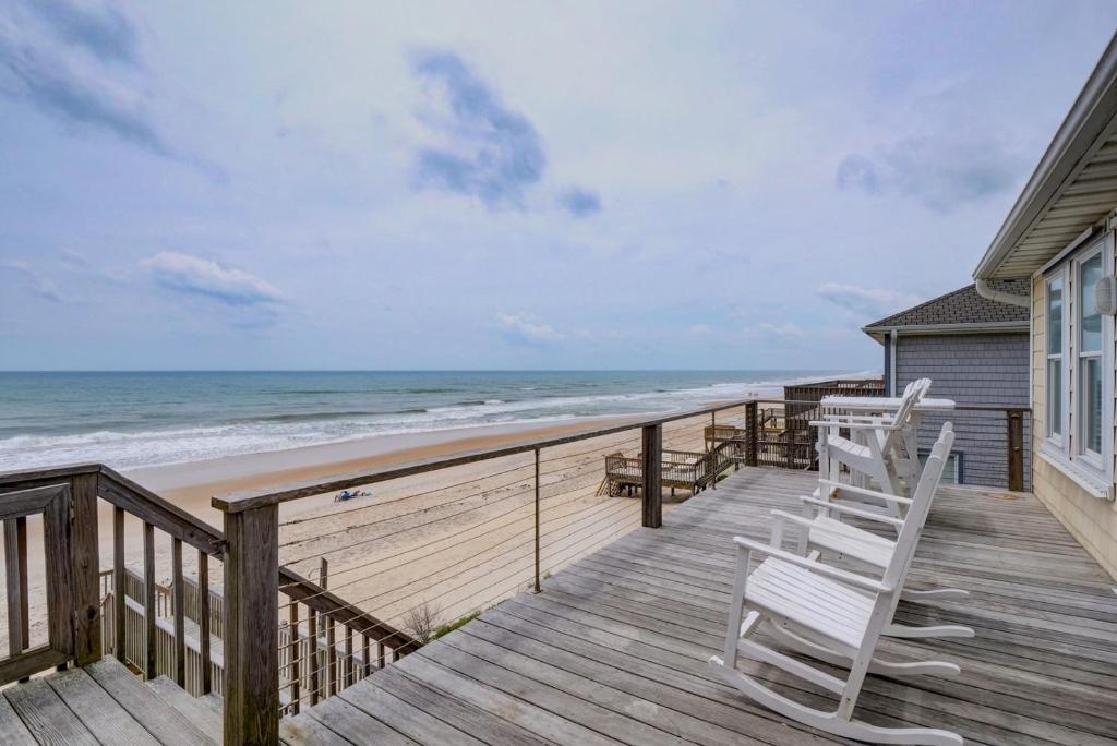 een terras met twee stoelen en het strand bij 1906-B S Shore Drive - Beg T' Go in Watts Landing