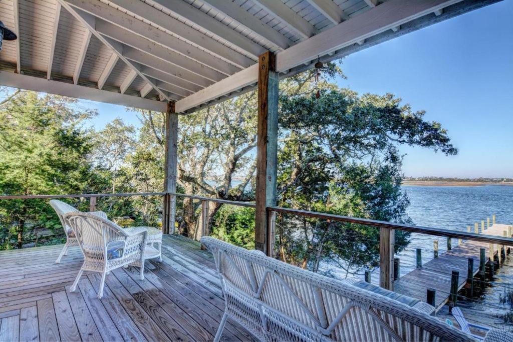 Un porche con sillas blancas y el agua. en 421 Fields Avenue - The Nancy Ann, en Topsail Beach