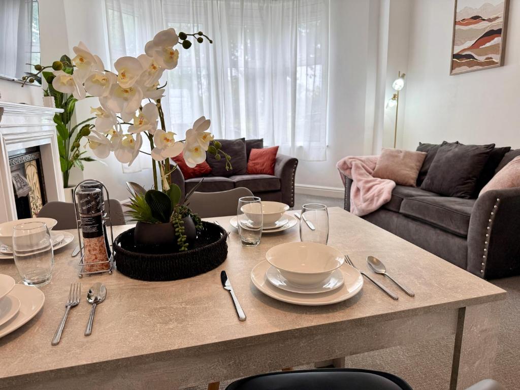 a living room with a table with plates and silverware at City Centre Embankment Apartments Superb Location in Cardiff