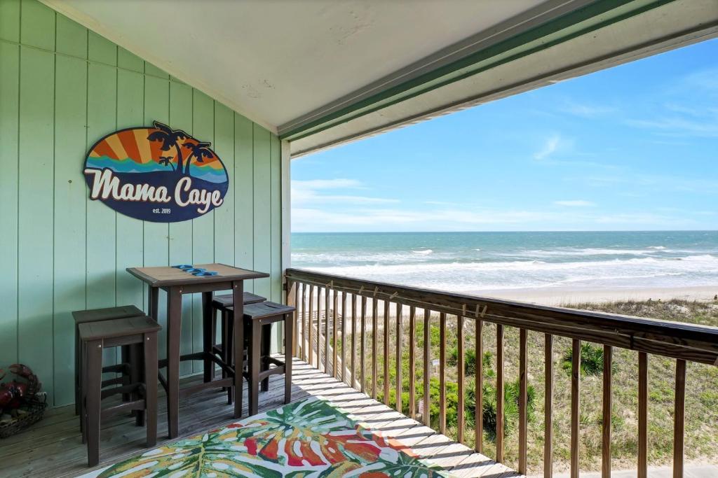a balcony with a table and chairs and the ocean at Surf Condos 737 in Surf City