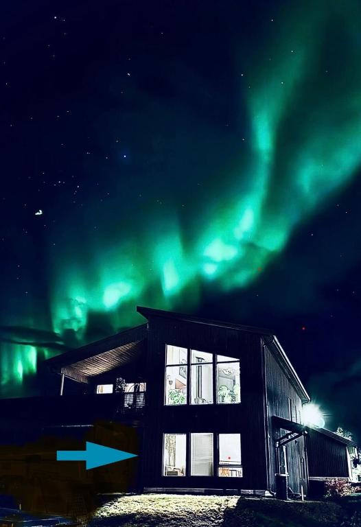 a house with the aurora in the sky at Eidekollen in Tromsø