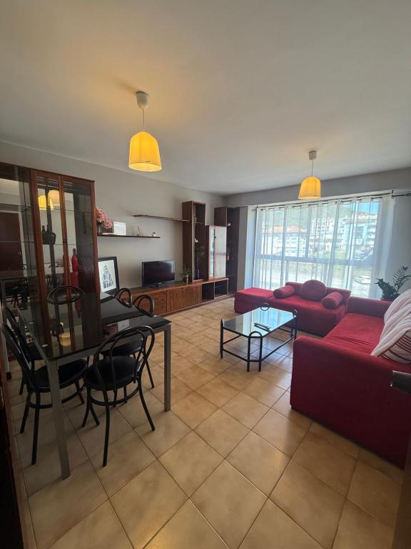 a living room with a red couch and a table at A de Olga in Porriño
